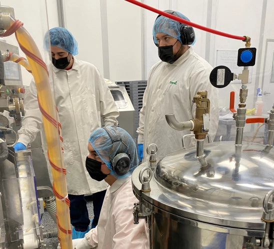 Three Vireo Resources employees wearing protective clothing inside the manufacturing plant.