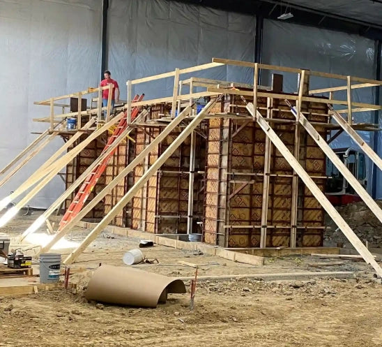 A wooden construction in progress inside a warehouse.